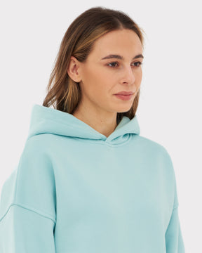 Frau trägt Oversized Hoodie 'Cody' in Hellblau mit Kapuze