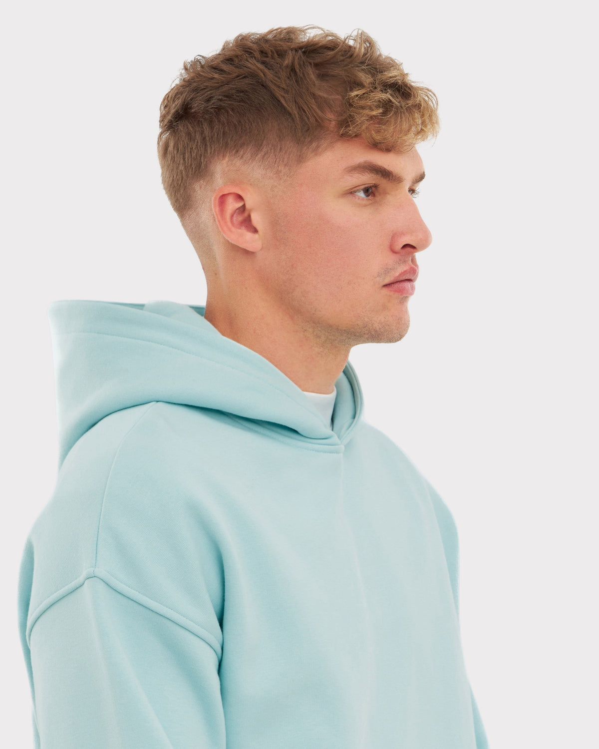 Mann trägt oversized Hoodie 'Cody' in eisblau, Seitenansicht
