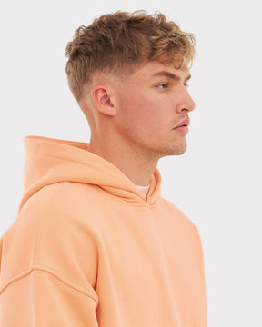 Mann im Profil trägt oversized Hoodie 'Cody' in Pfirsichfarbe mit Kapuze