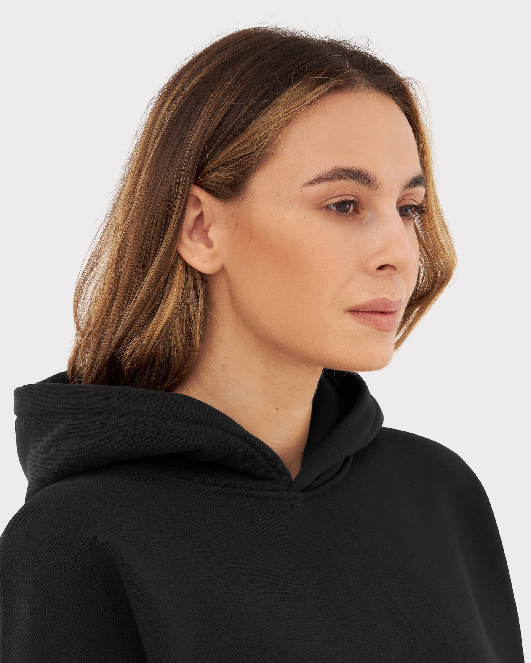 Frau mit mittellangen braunen Haaren trägt schwarzen Oversized Hoodie 'Cody'