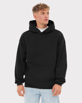 Mann trägt schwarzen oversized Hoodie 'Cody' mit Kängurutasche und Kapuze, kombiniert mit hellblauen Jeans