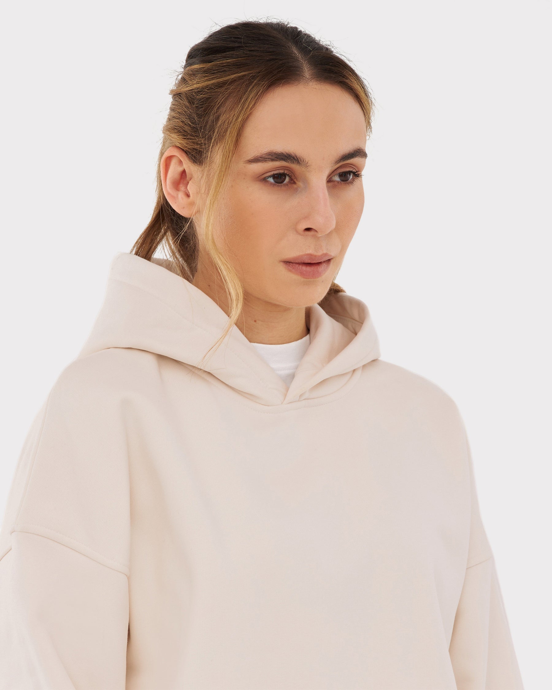 Frau trägt oversized Hoodie 'Cody' in hellem Beige mit Kapuze