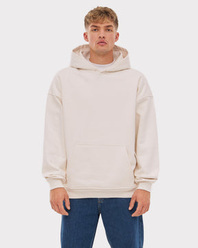Mann trägt beigen Oversized Hoodie 'Cody' mit Kängurutasche und Kapuze