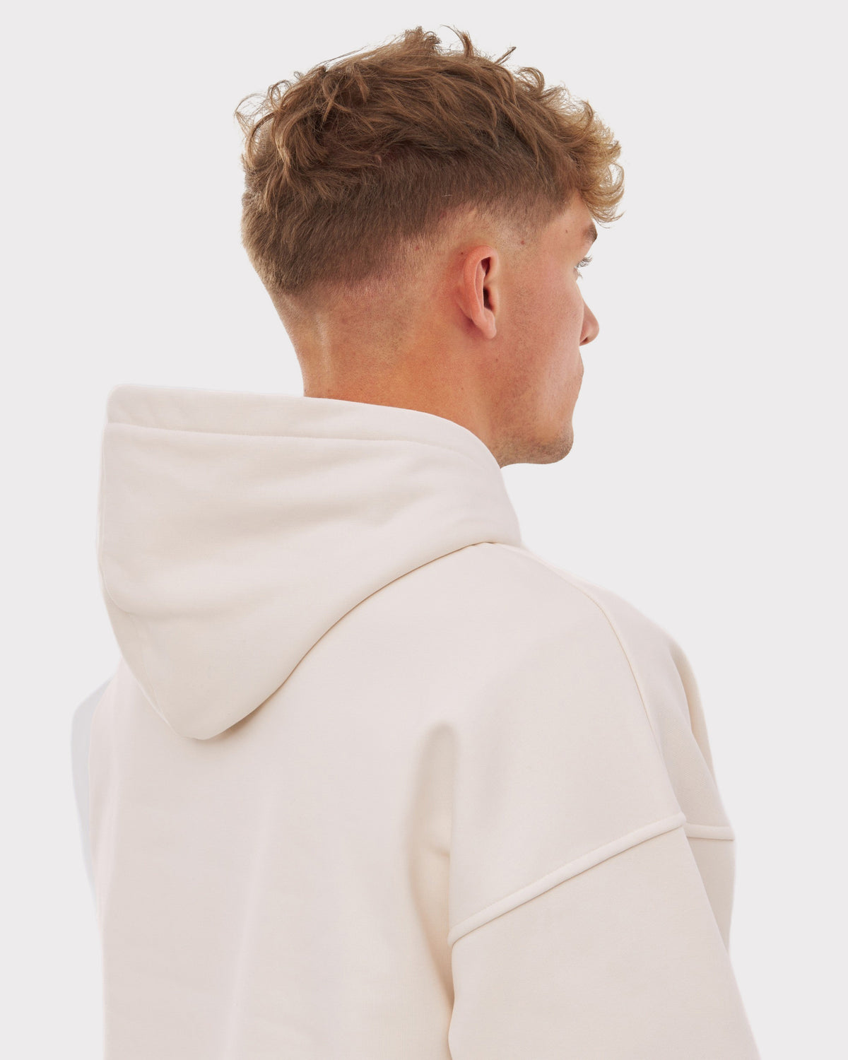 Junger Mann von hinten mit beigem Oversized Hoodie 'Cody' mit großer Kapuze