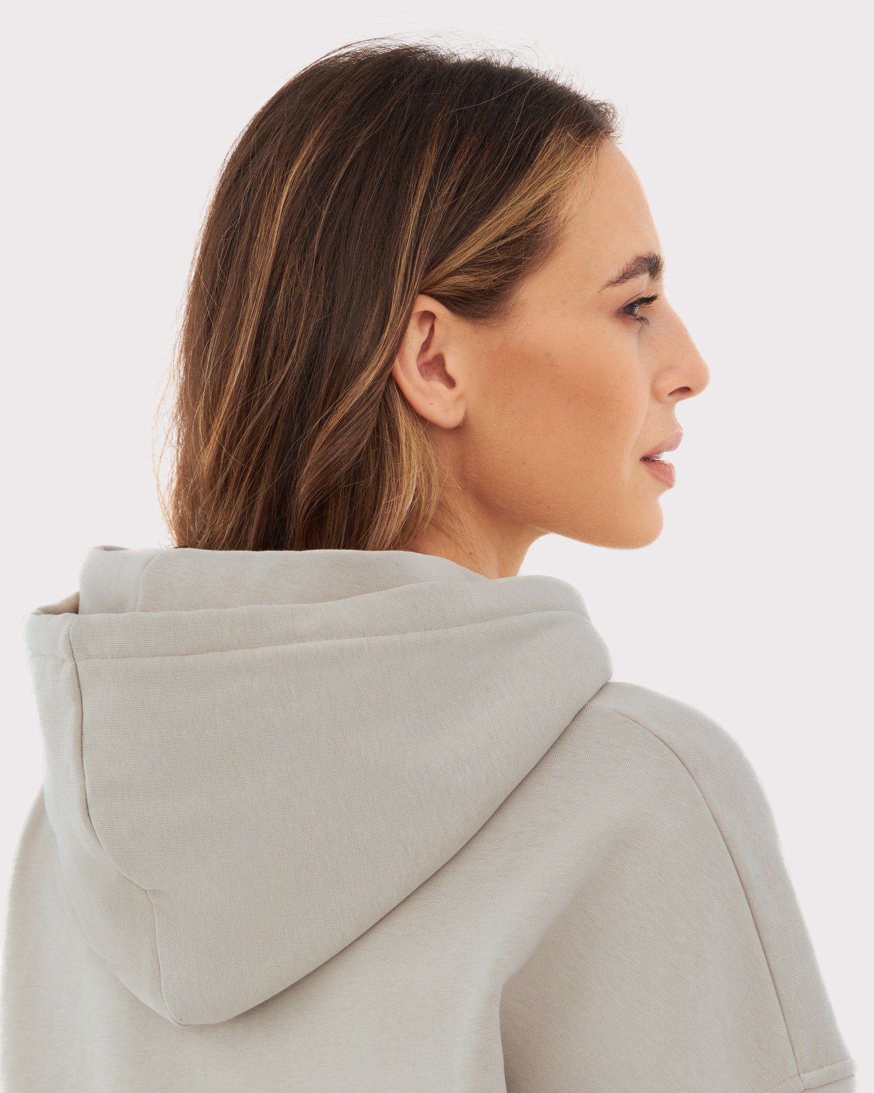 Frau von der Seite trägt oversized Hoodie 'Cody' in hellem Beige mit Kapuze