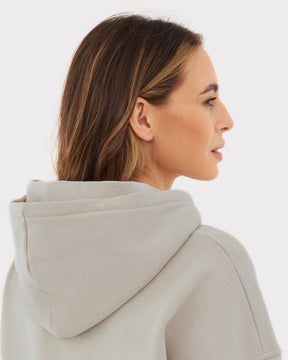 Frau von der Seite trägt oversized Hoodie 'Cody' in hellem Beige mit Kapuze