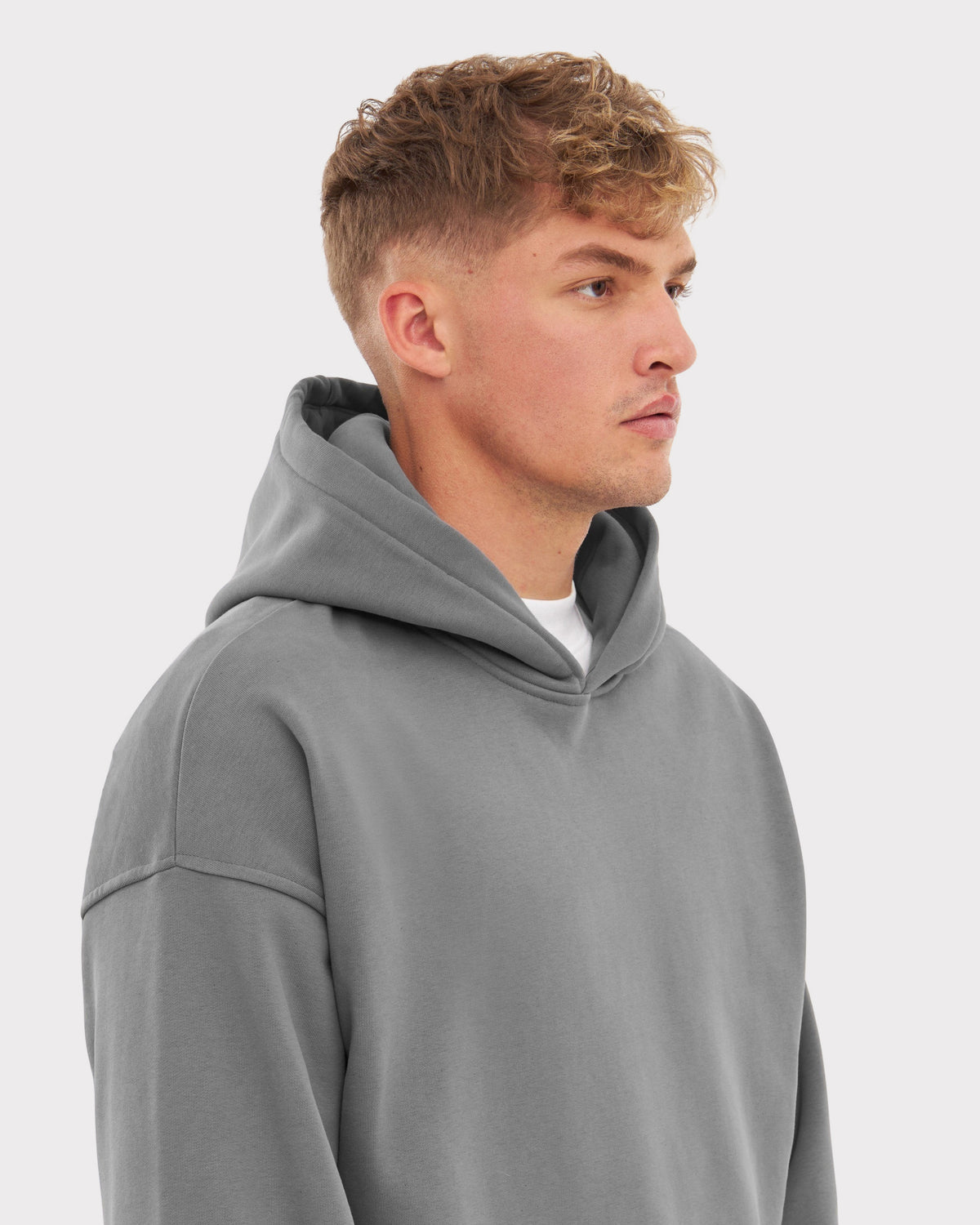 Mann im Profil mit grauem Oversized Hoodie 'Cody' und hellem T-Shirt darunter