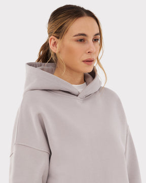 Frau trägt oversized Hoodie "Cody" in hellem Grau mit Kapuze