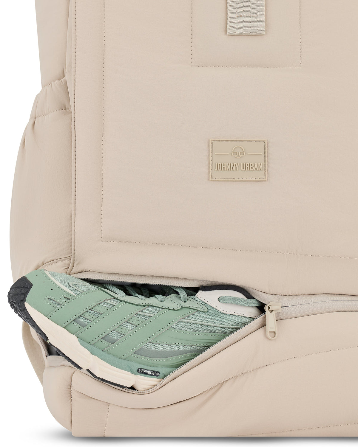 Sandfarbener Rolltop-Rucksack 'Kyle' von Johnny Urban mit geöffnetem Reißverschlussfach, darin grün-weißer Sportschuh