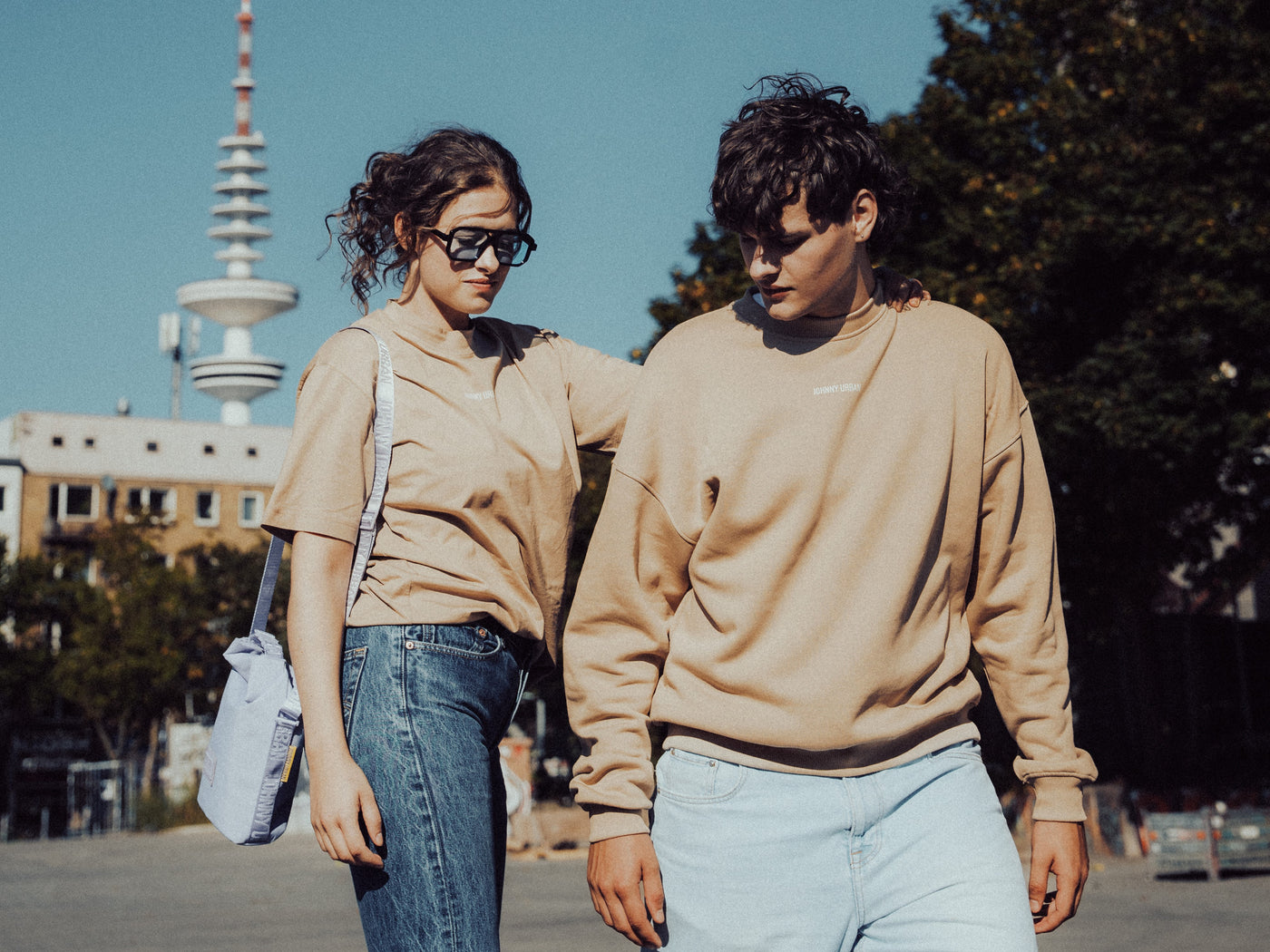 Ein Mann und eine Frau in Johnny Urban Klamotten unterwegs vor dem Hamburger Fernsehturm. 