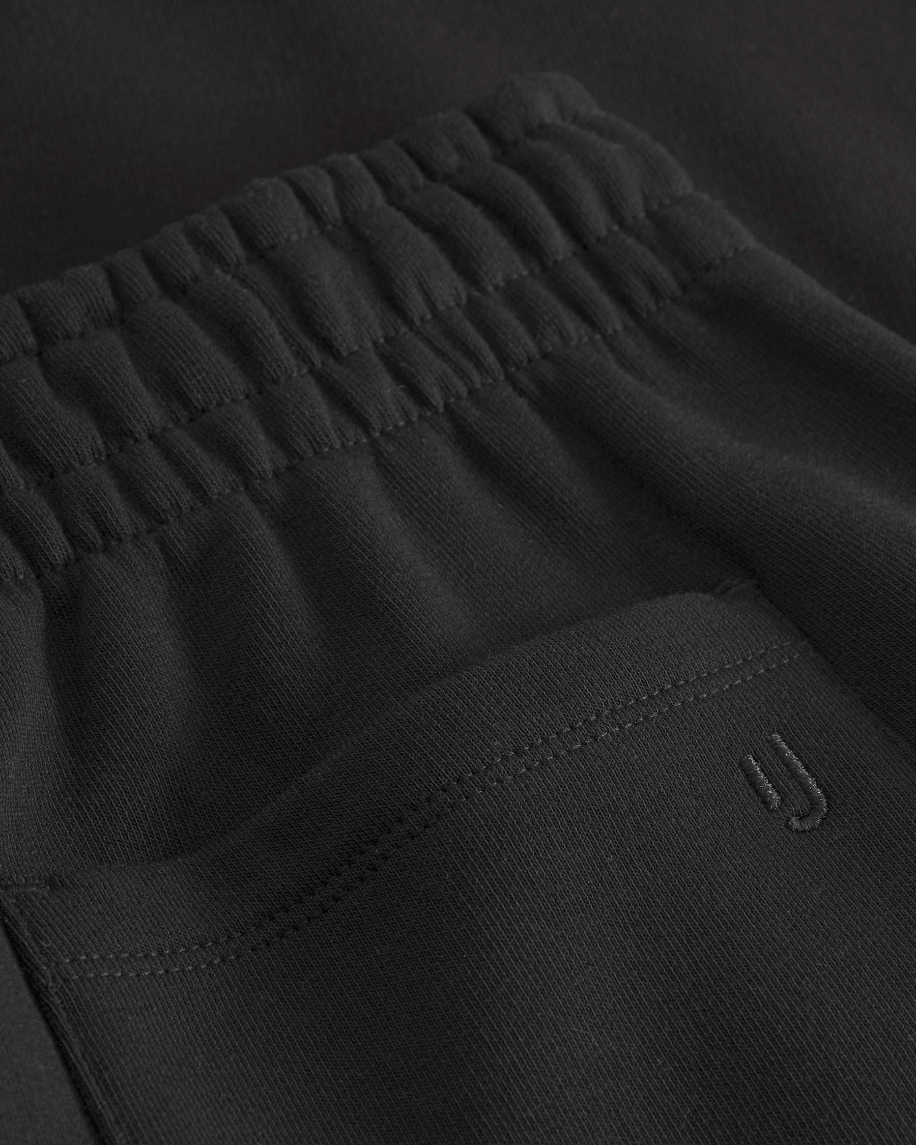 Schwarze Jogginghose 'Owen' mit elastischem Bund und eingesticktem 'JU'-Logo auf der Tasche
