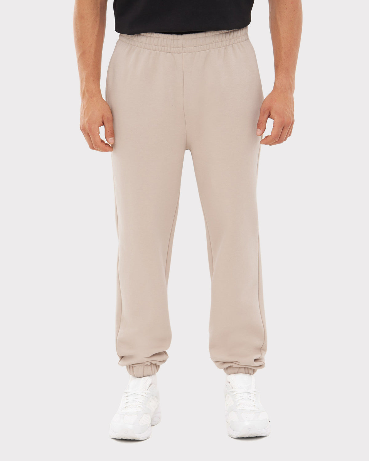 Beige Herren-Jogginghose 'Owen' mit elastischem Bund und Bündchen, getragen mit weißen Sneakern