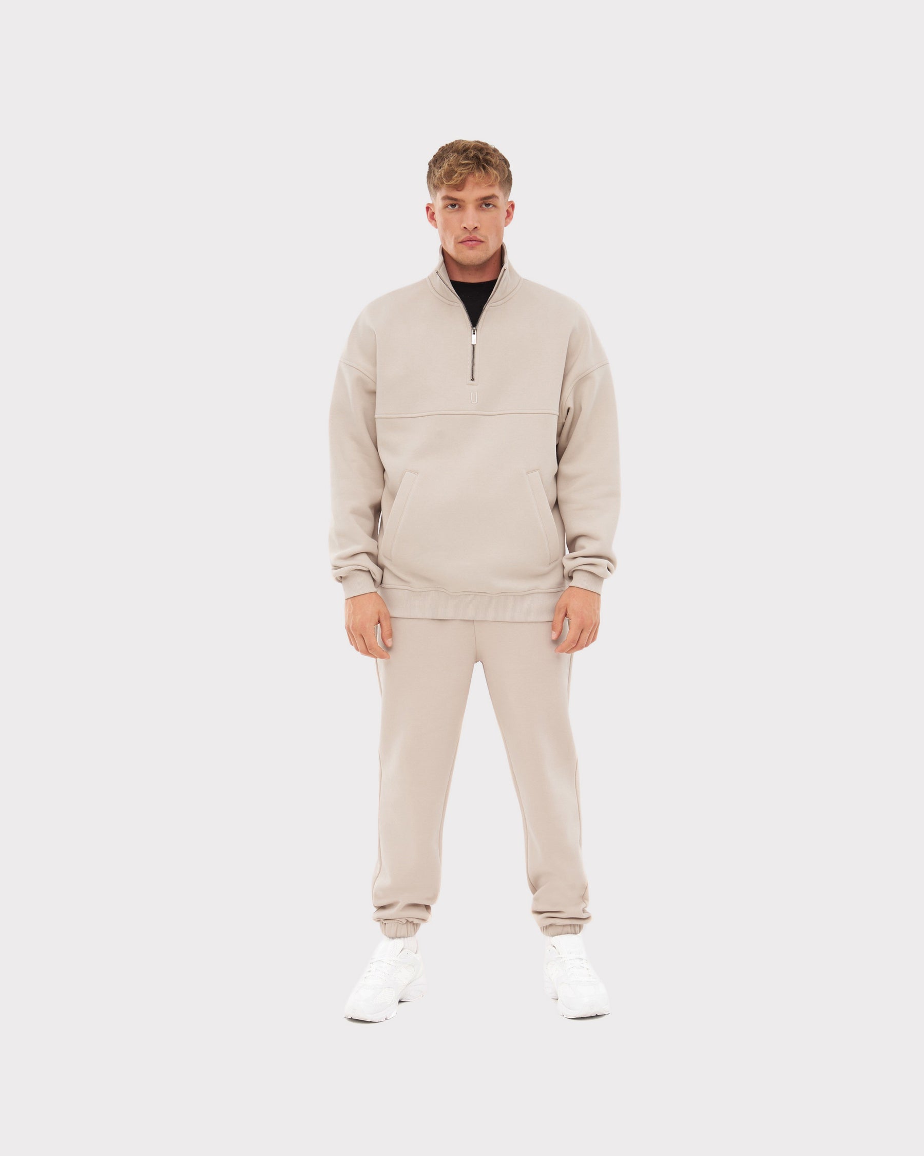 Mann trägt beige Jogginghose 'Owen' und passenden Pullover mit halbem Reißverschluss