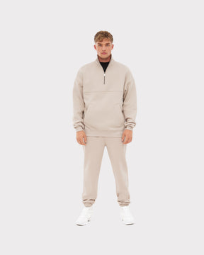 Mann trägt beige Jogginghose 'Owen' und passenden Pullover mit halbem Reißverschluss