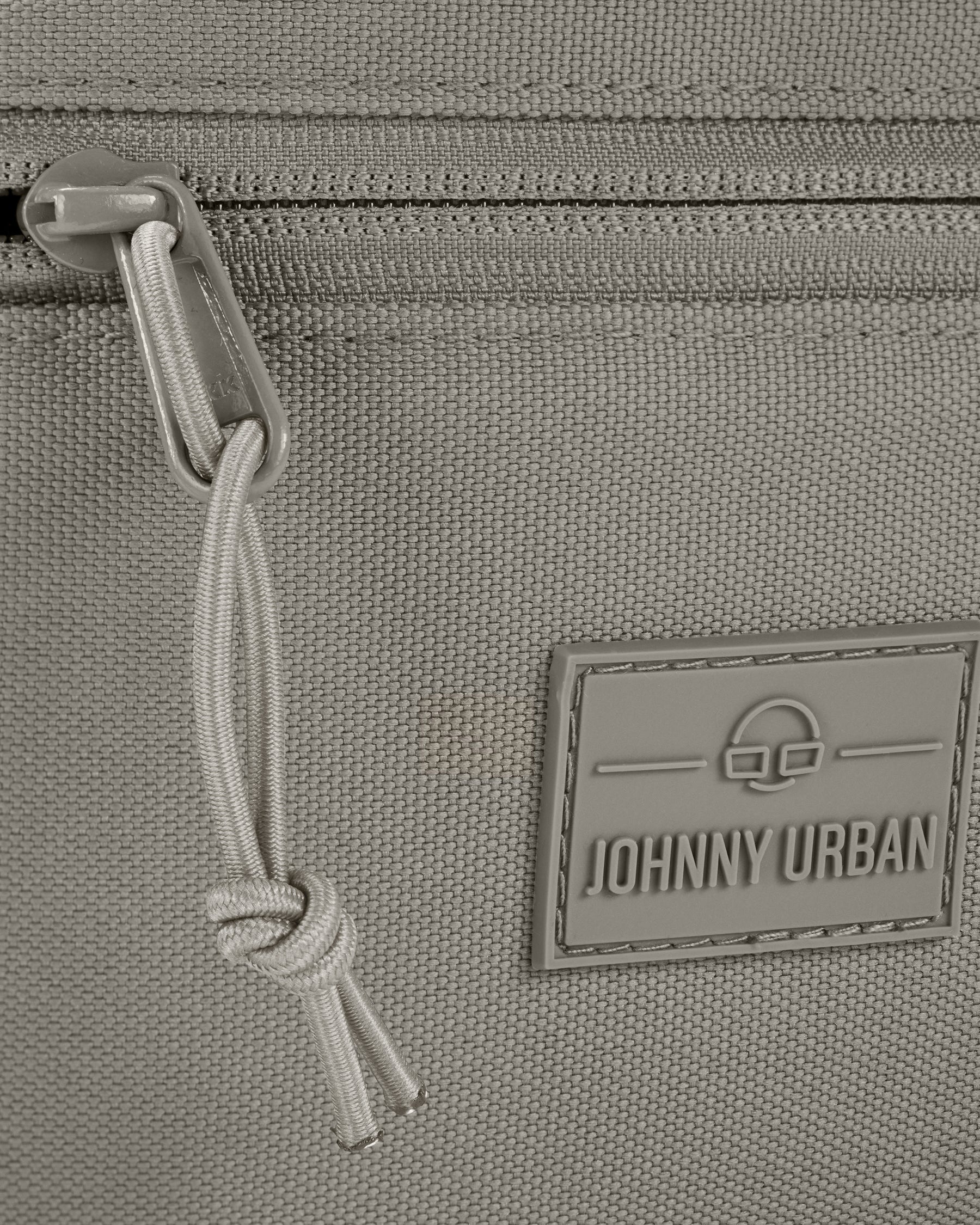 Detailansicht eines Reißverschlusses und des Johnny Urban Logos auf der Bauchtasche 'Erik Large' in desert grey