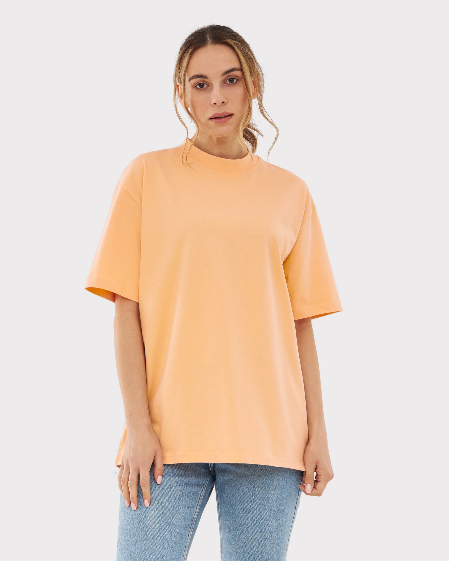 Frau trägt oversized T-Shirt 'Sammy' in Pfirsich mit kurzen Ärmeln und rundem Ausschnitt