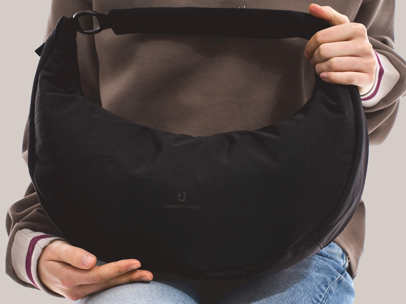 Unser weibliches Model präsentiert die Half-Moon-Bag "Lou Large" hier im Closeup von vorne. 