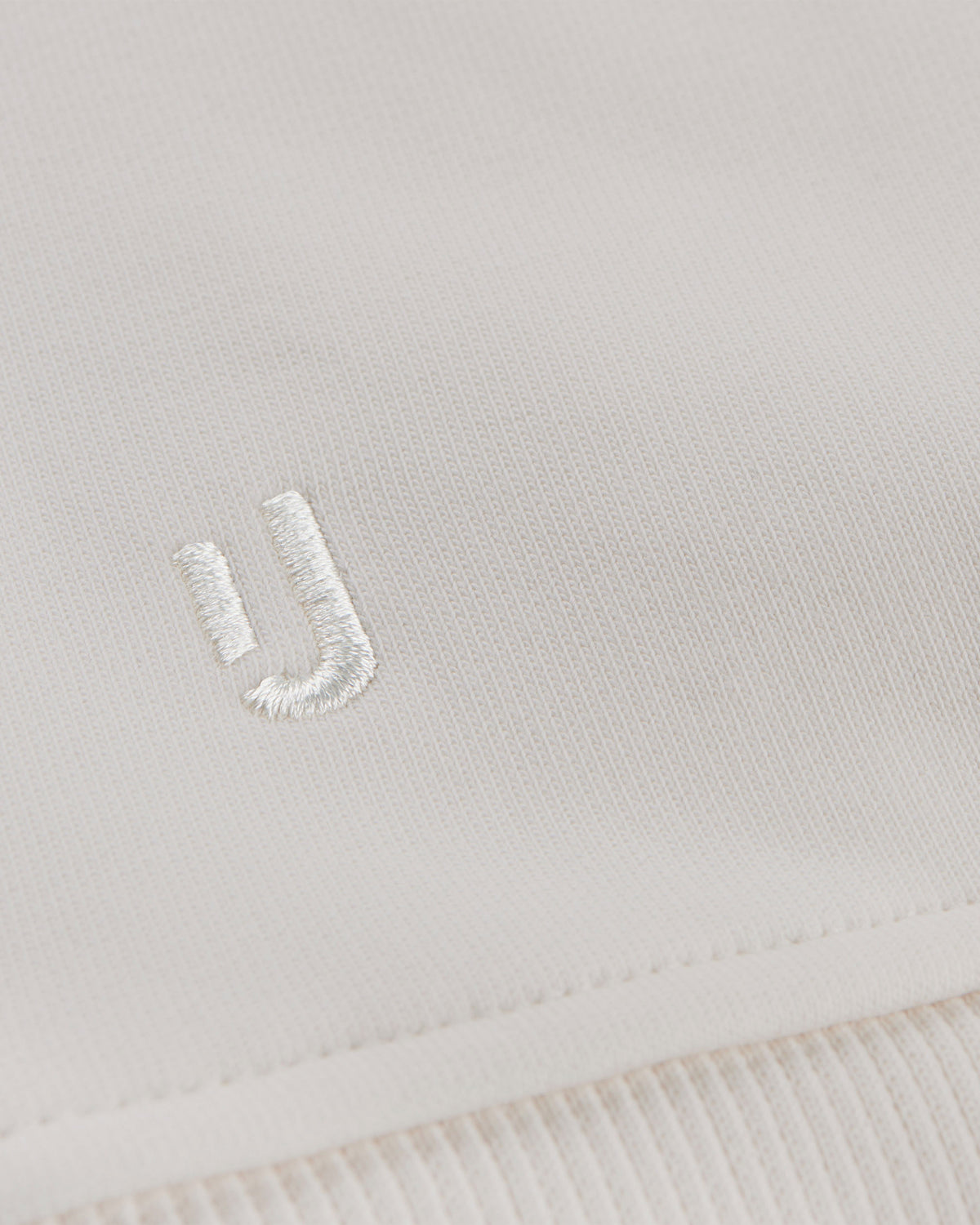 Nahe Ansicht des weißen gestickten Johnny-Urban-Logos auf cremeweißem Oversized Hoodie 'Cody'