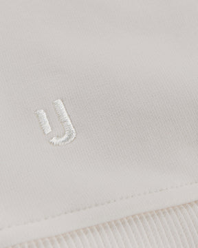 Nahe Ansicht des weißen gestickten Johnny-Urban-Logos auf cremeweißem Oversized Hoodie 'Cody'