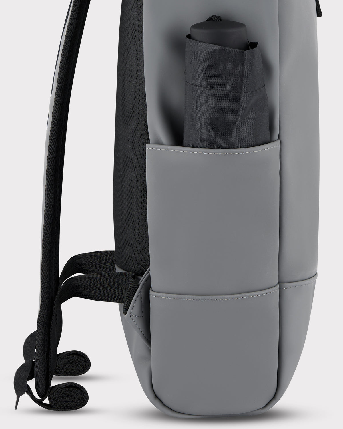 Seitenansicht des grauen Johnny Urban Rolltop Rucksack 'Harvey Medium' mit verschlossener Außentasche