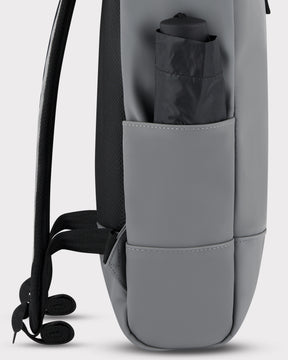 Seitenansicht des grauen Johnny Urban Rolltop Rucksack 'Harvey Medium' mit verschlossener Außentasche