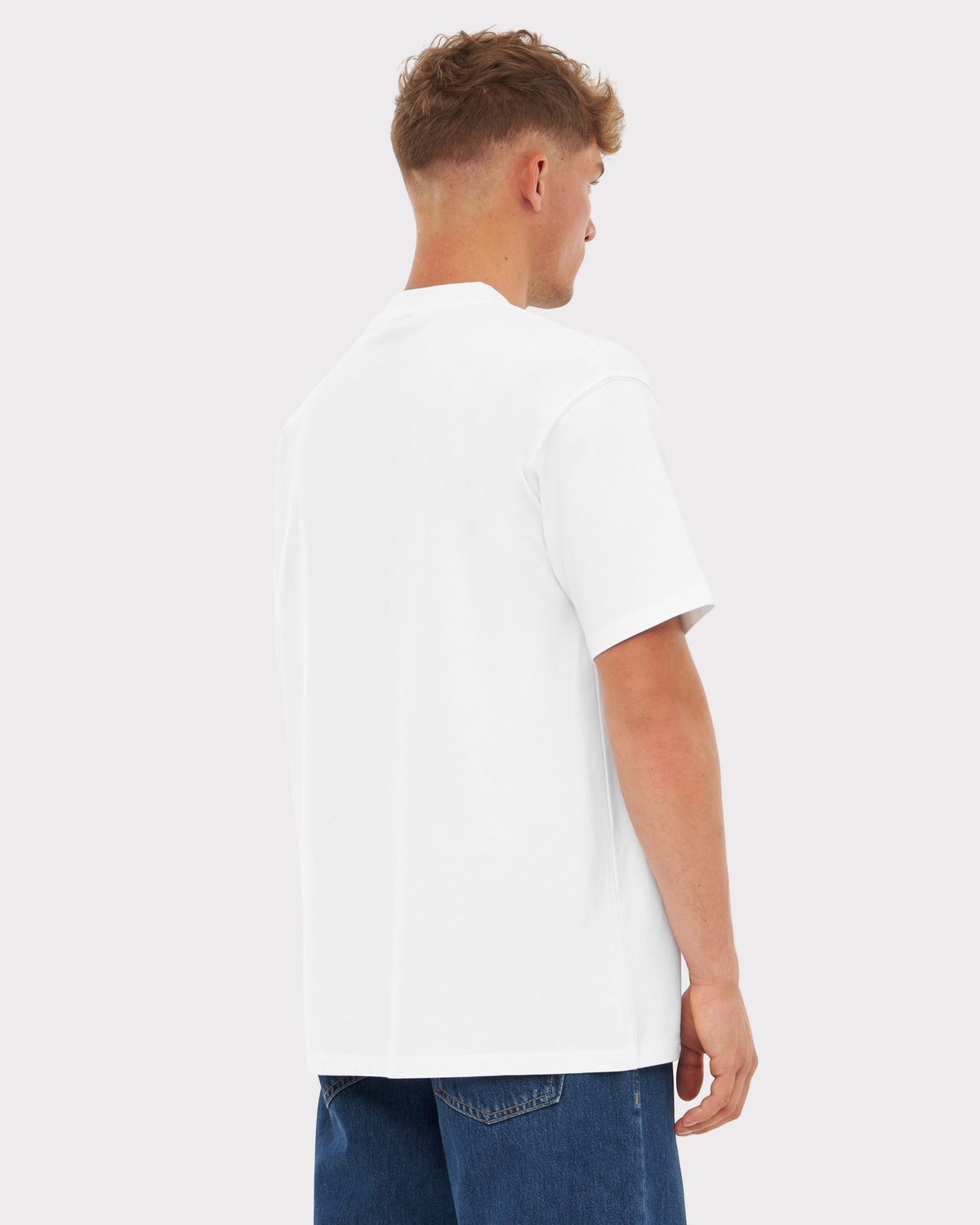 Mann von hinten trägt oversized weißes T-Shirt 'Sammy' und blaue Jeans