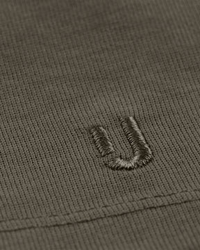 Nahaufnahme des grauen Stoffes mit gesticktem Johnny Urban Logo