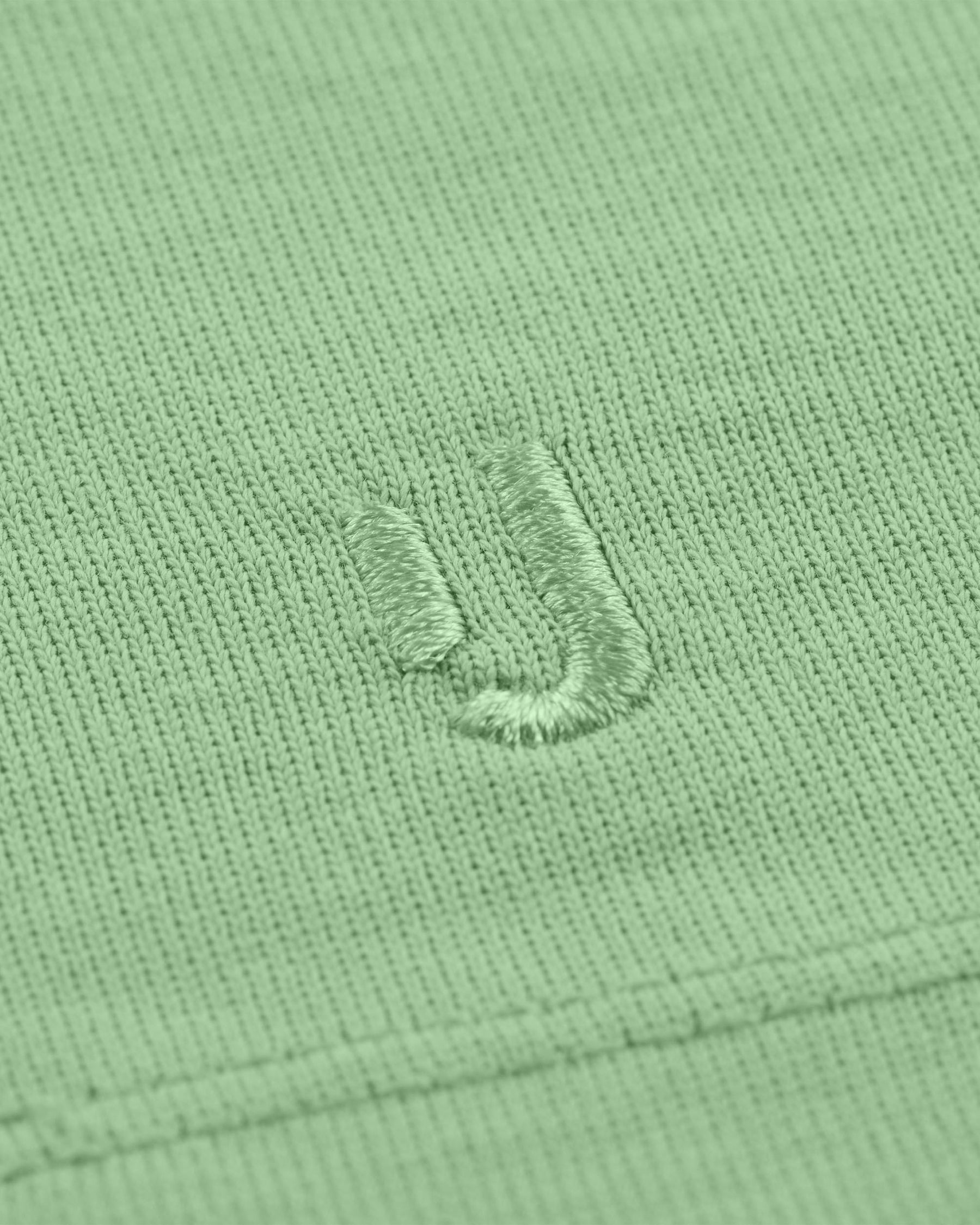Nahaufnahme des gestickten Johnny Urban Logos auf dem T-Shirt 'Sammy' in Salbeigrün