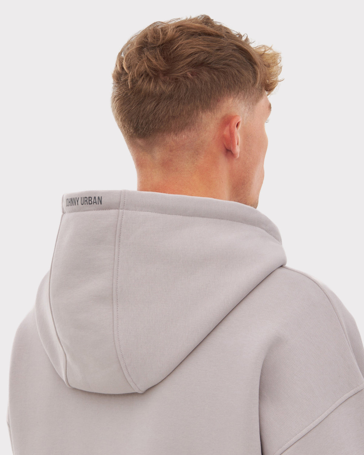 Rückansicht eines Mannes mit kurzem Haar, der einen oversized Zip Hoodie 'Caleb' in Grau-Beige von Johnny Urban trägt