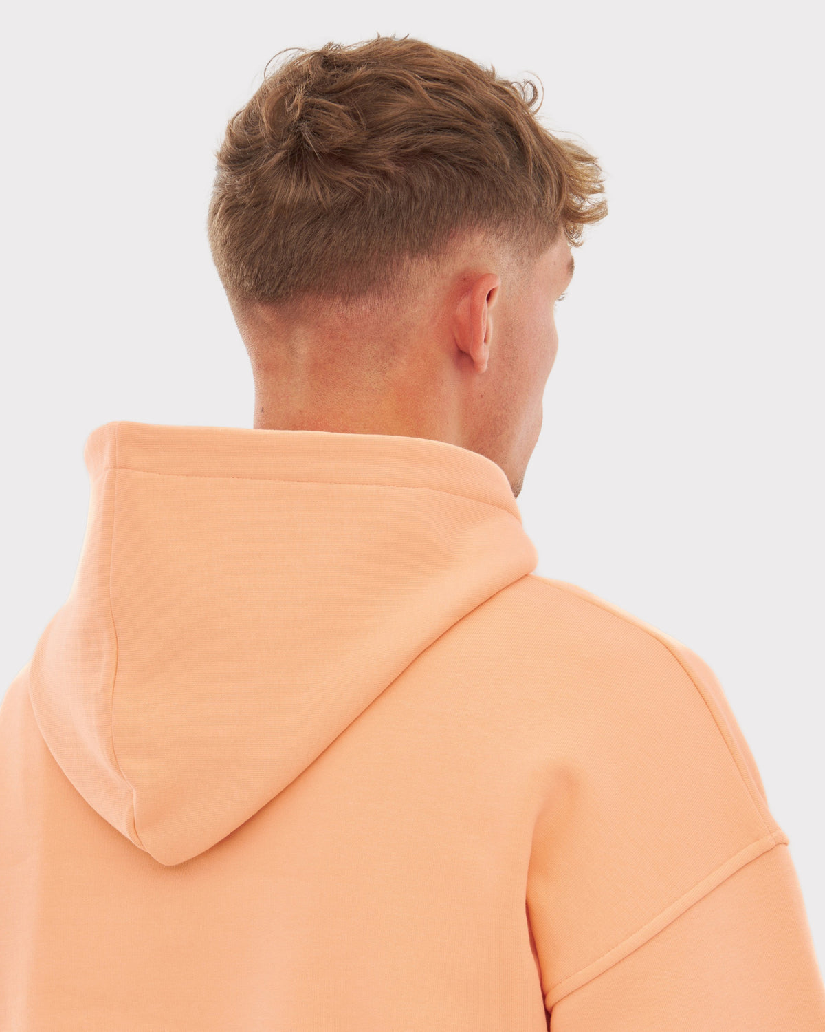 Überdimensionaler Herren-Kapuzenpullover 'Cody' in Pfirsich, Rückansicht mit Kapuze
