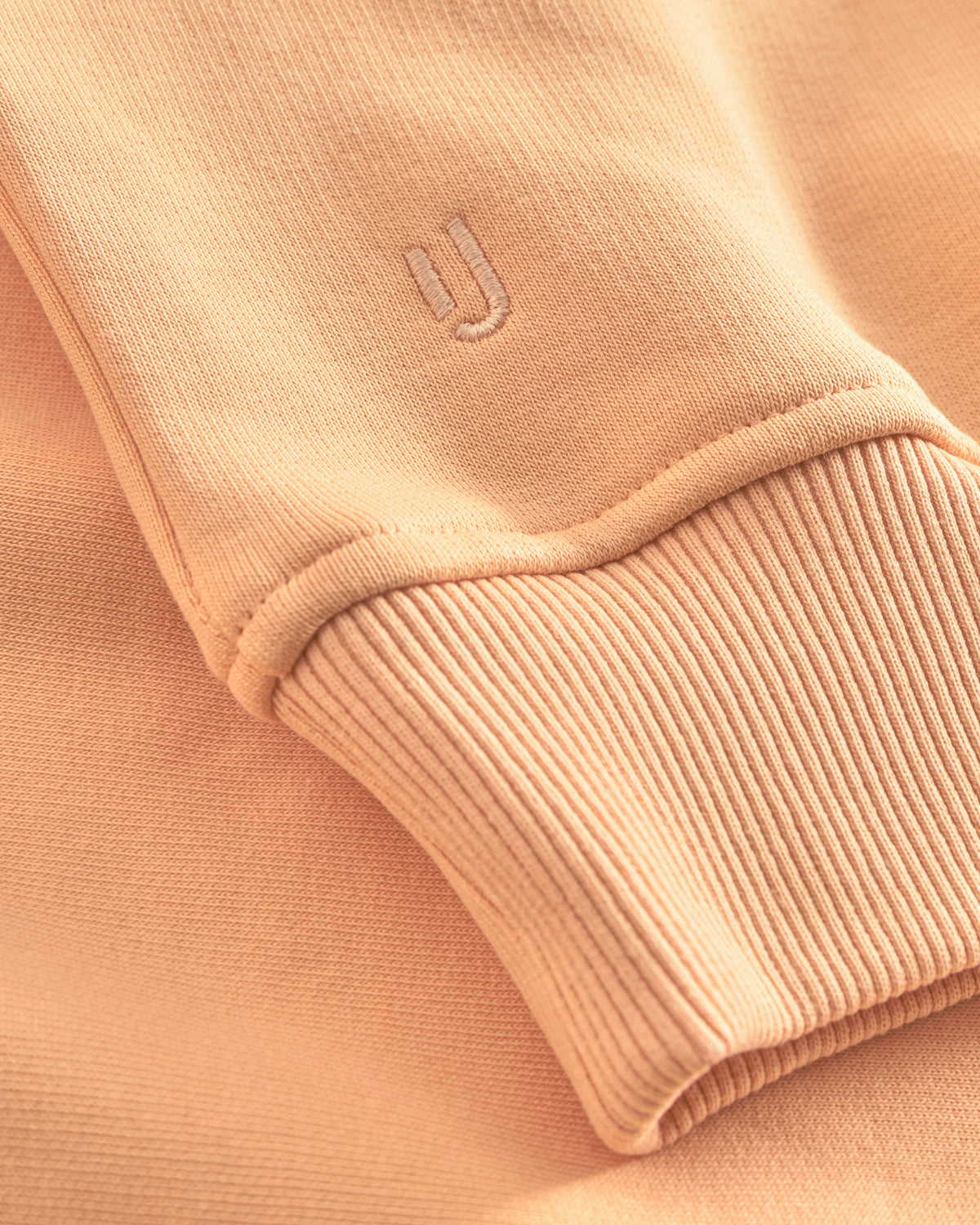 Ärmelabschluss eines peachfarbenen Oversized Hoodies "Cody" mit Johnny Urban Sticklogo