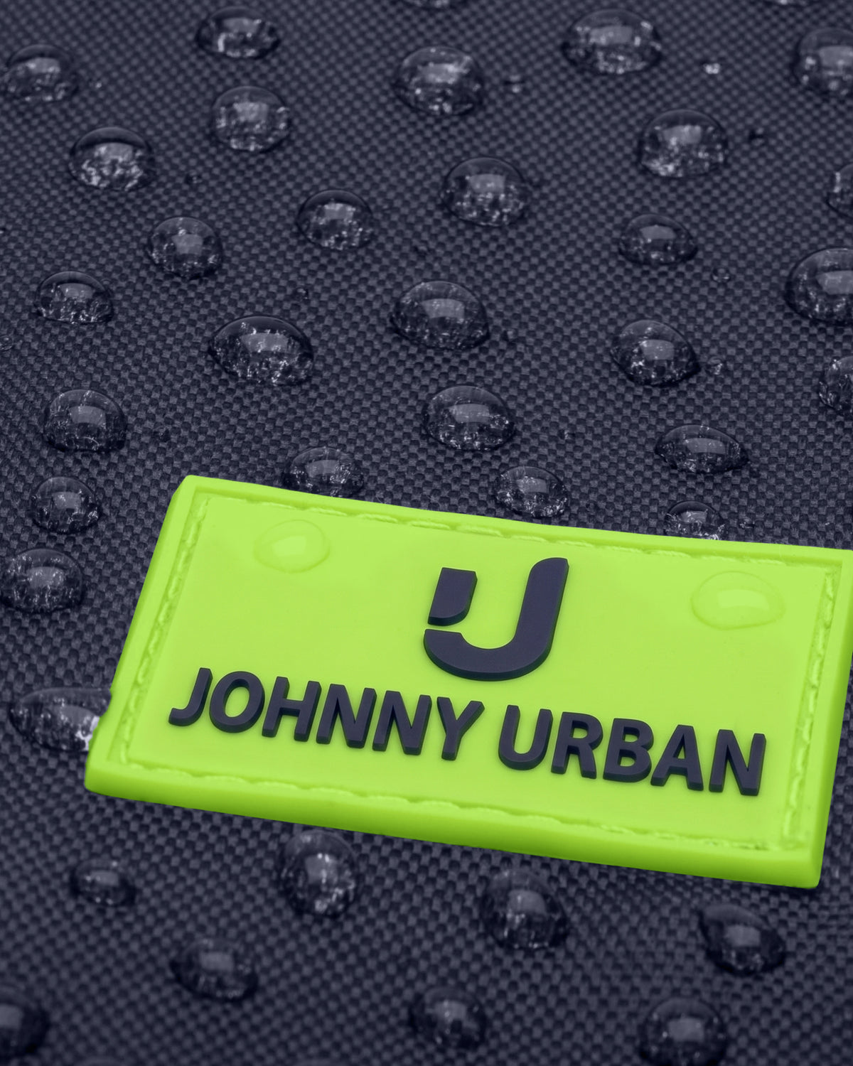Nahe Aufnahme eines wasserabweisenden, dunkelblauen Kinder-Turnbeutels mit neongrünem Aufnäher 'Johnny Urban Junior'