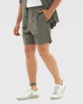 Männliche Beine mit olivgrüner Mason Shorts aus leichtem Material und weißen Sneakern