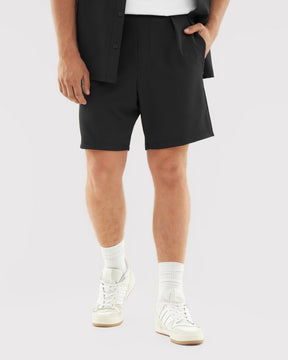 Schwarze kurze Hose aus dem Set 'Mason' für Herren, kombiniert mit weißen Sneakern und Socken
