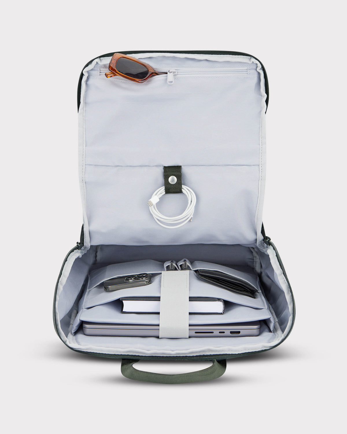 Geöffneter grüner Business Rucksack 'Jasper' mit Laptop, Buch, Schlüssel, Brieftasche, Kabel und Sonnenbrille innen
