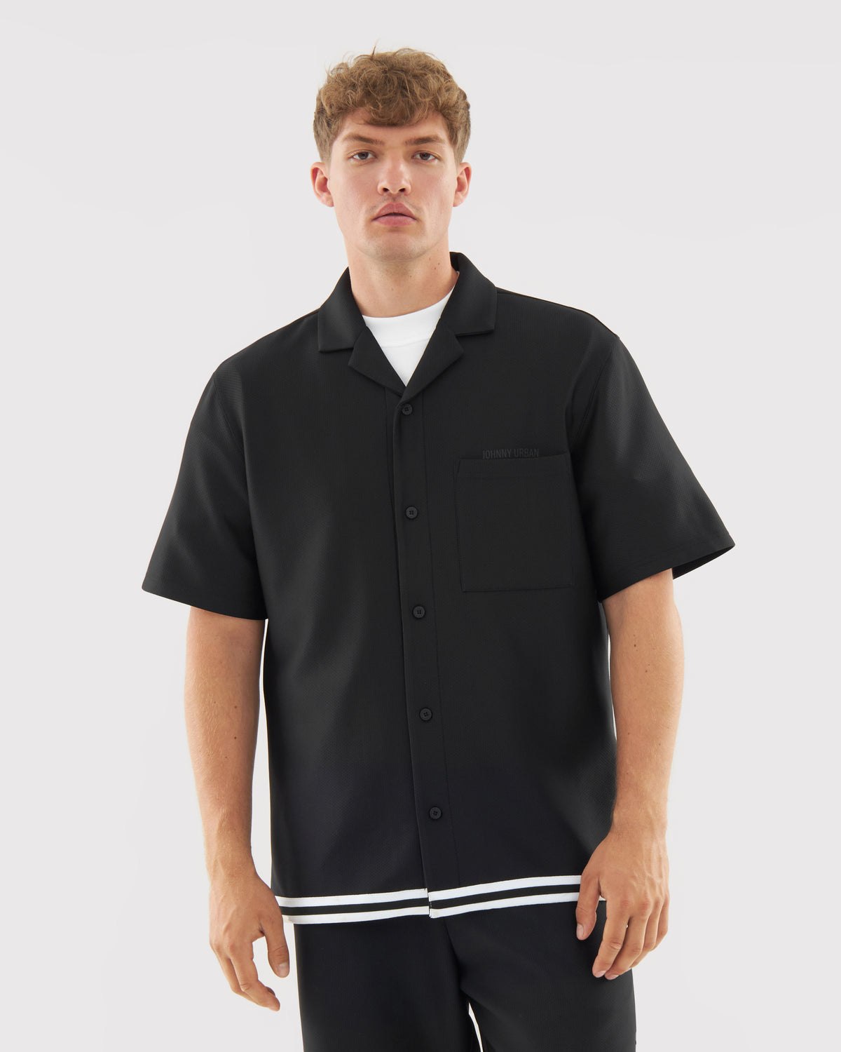 Mann trägt schwarzes kurzärmeliges Hemd mit weißem Unterhemd, Teil des 'Parker' Sets