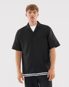 Mann trägt schwarzes kurzärmeliges Hemd mit weißem Unterhemd, Teil des 'Parker' Sets