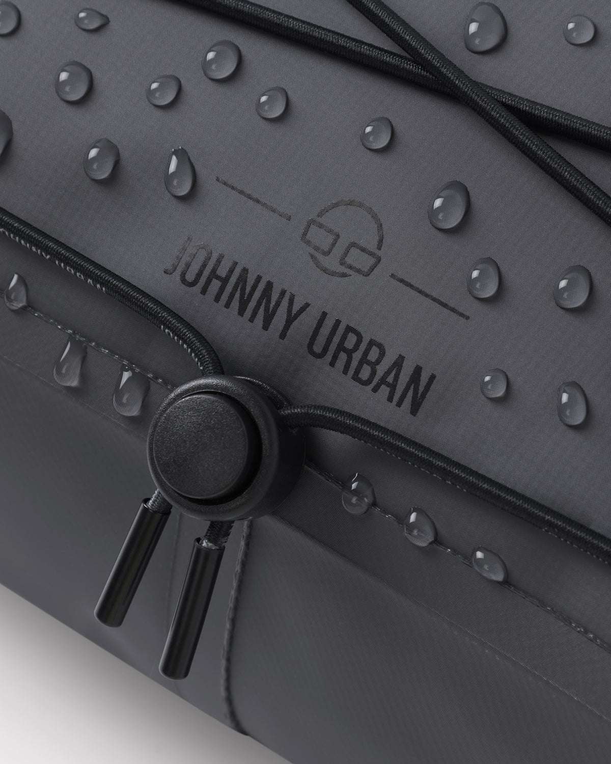 Naheinstellung der schwarzen Lenkertasche 'Arlo' von Johnny Urban mit Wasserperlen auf der Oberfläche