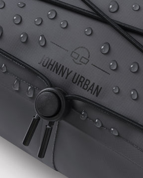 Naheinstellung der schwarzen Lenkertasche 'Arlo' von Johnny Urban mit Wasserperlen auf der Oberfläche