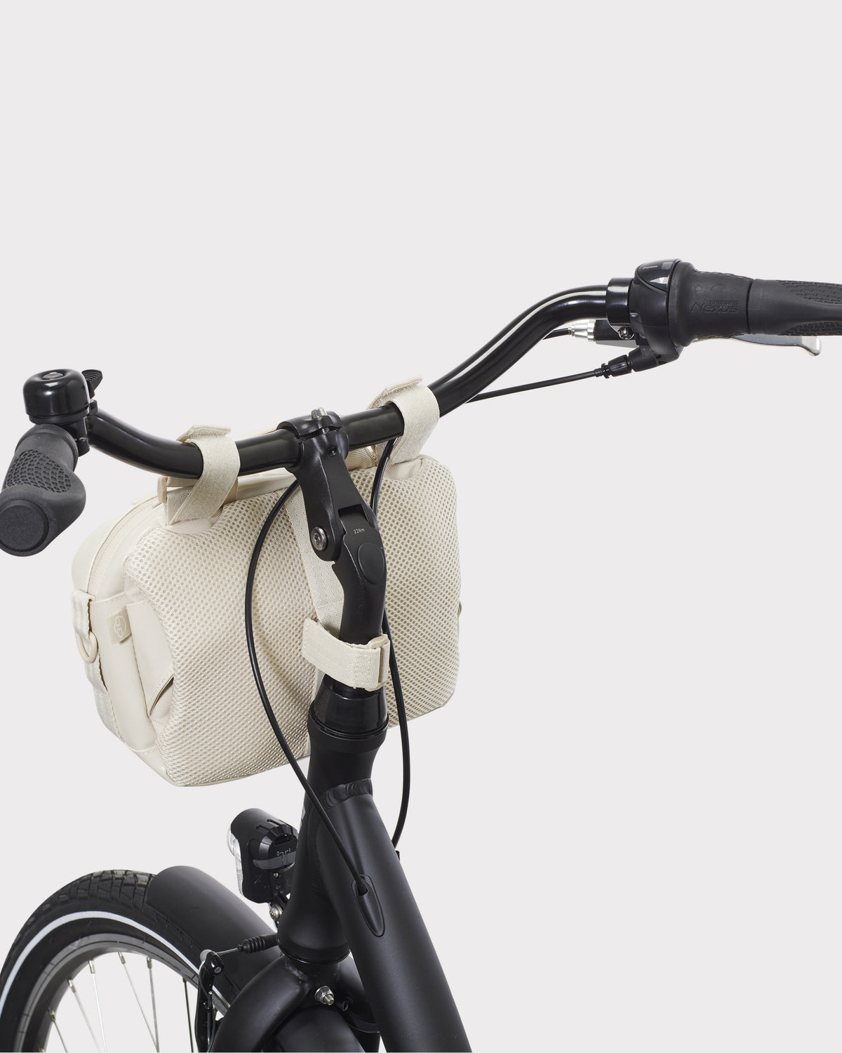 Beige Lenkertasche 'Nelson' von Johnny Urban am schwarzen Fahrradlenker befestigt