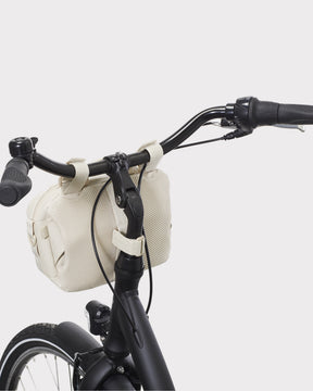 Beige Lenkertasche 'Nelson' von Johnny Urban am schwarzen Fahrradlenker befestigt