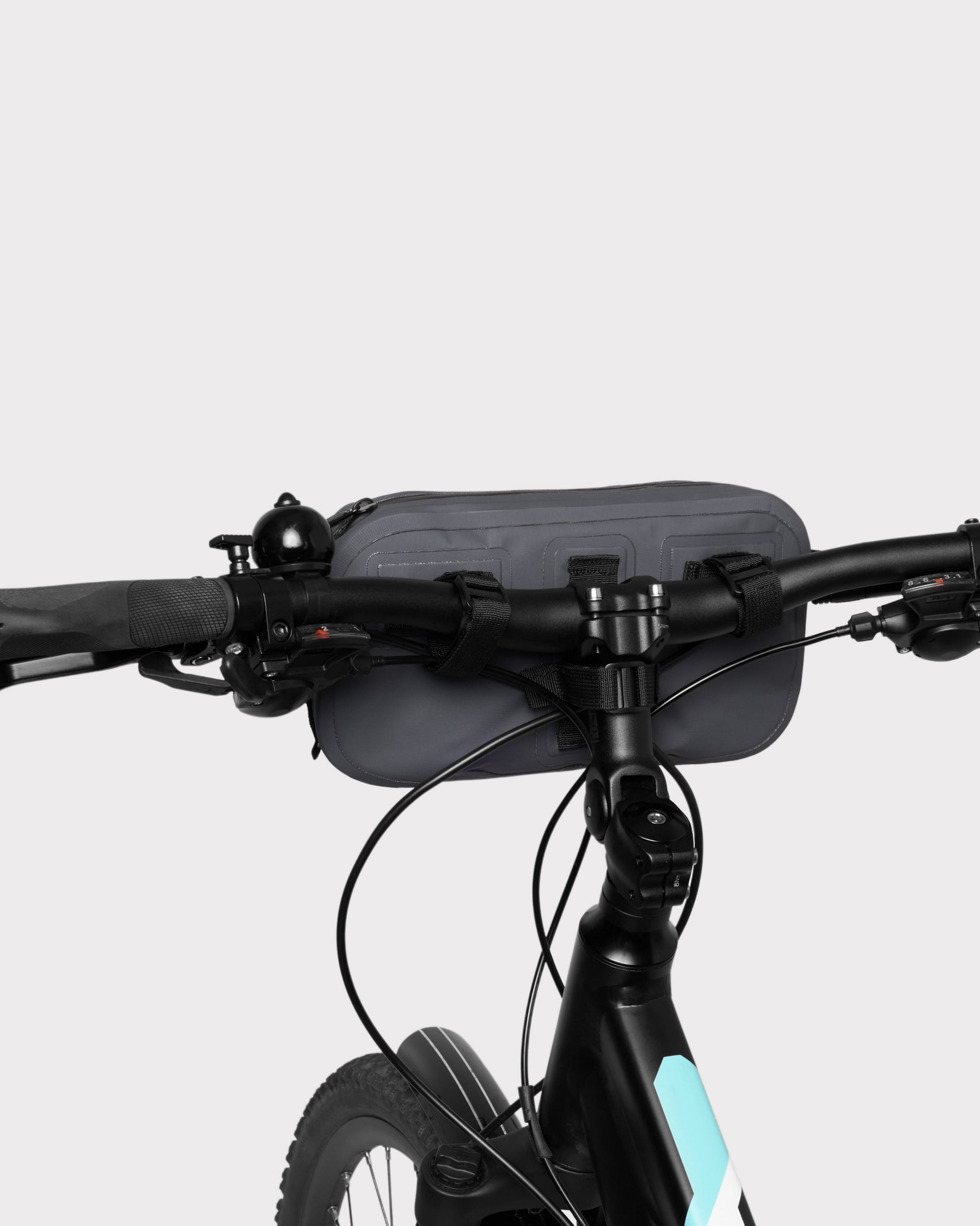Graue Lenkertasche 'Arlo' am schwarzen Fahrradlenker befestigt mit drei schwarzen Klettverschlüssen
