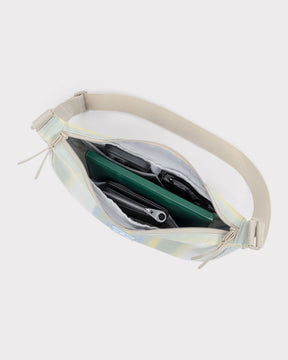 Geöffnete Half Moon Bag 'Ally Medium' mit sichtbaren Fächern, schwarzer Geldbörse, grüner Mappe und schwarzen Sonnenbrillen