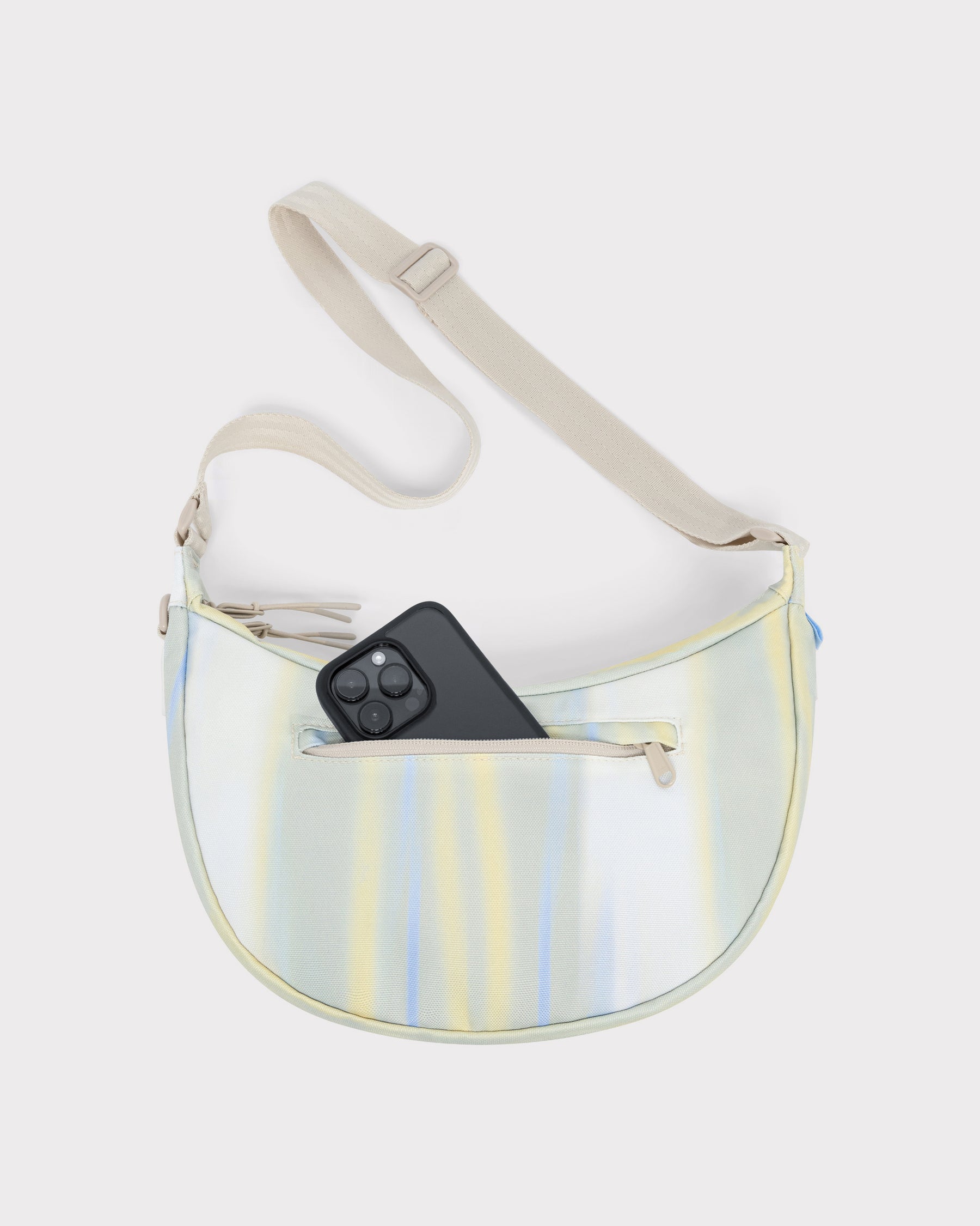 Half Moon Bag 'Ally Medium' in pastellfarbenem Streifenmuster mit Vorderfach und schwarzem Smartphone