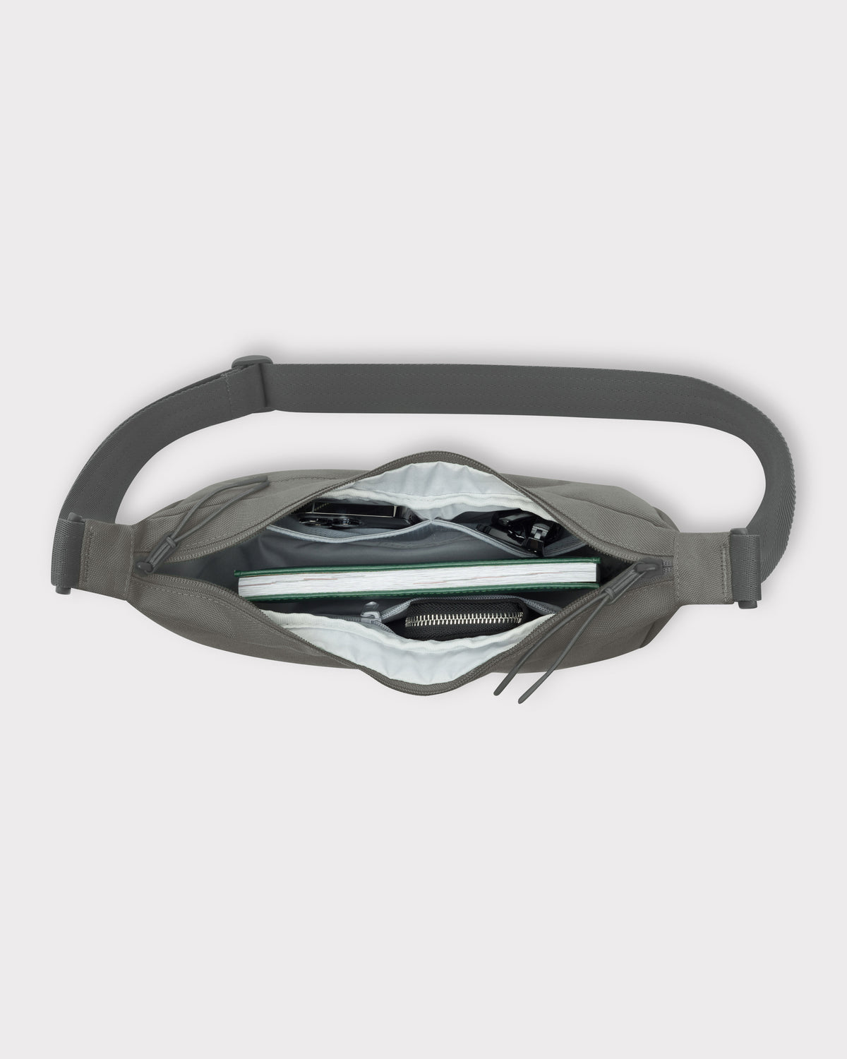 Halbmondtasche "Ally Medium" in Grau mit mehreren Fächern, teilweise gefüllt mit Brille, Schlüssel, Buch und Geldbörse