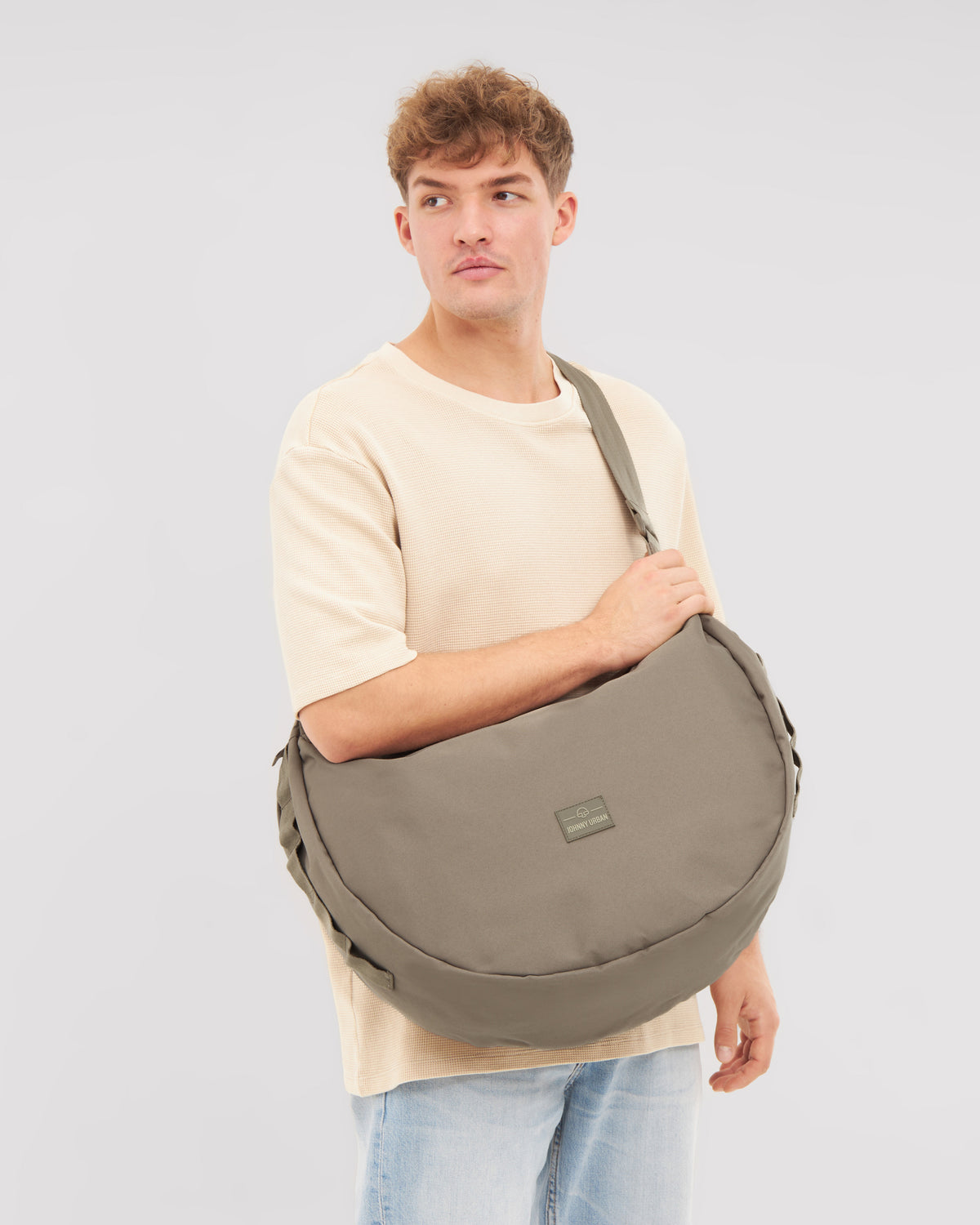 Mann trägt half moon Bag 'Ally XL' in Grau quer über die Schulter