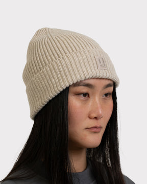 Beige gestrickte Mütze 'Billie' von Johnny Urban an Frau mit langen schwarzen Haaren