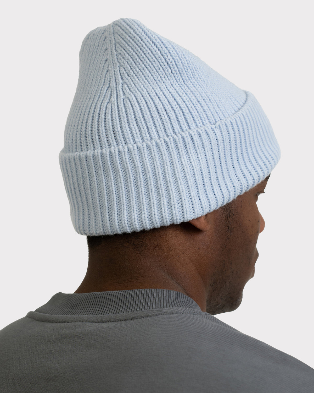 Hellblaue Strickmütze 'Billie' auf dem Kopf eines Mannes von hinten