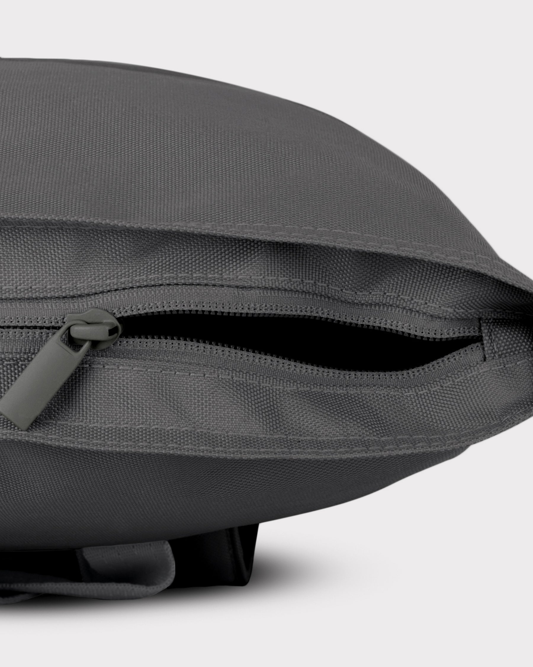 Dunkelgrauer nachhaltiger Rolltop Rucksack 'Robin Medium' mit geöffnetem seitlichem Reißverschluss