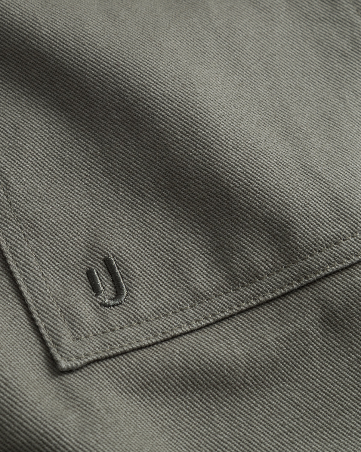 Detailaufnahme der grüngrauen Baumwoll-Overshirttasche 'Cameron' mit gesticktem Markenlogo